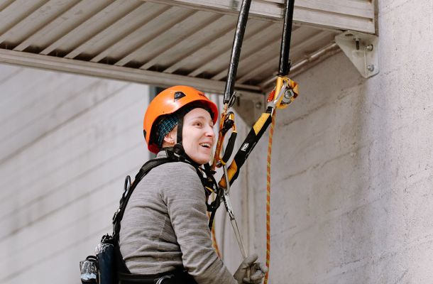 travailleuse sur cordes équipée d’un harnais et casque de sécurité